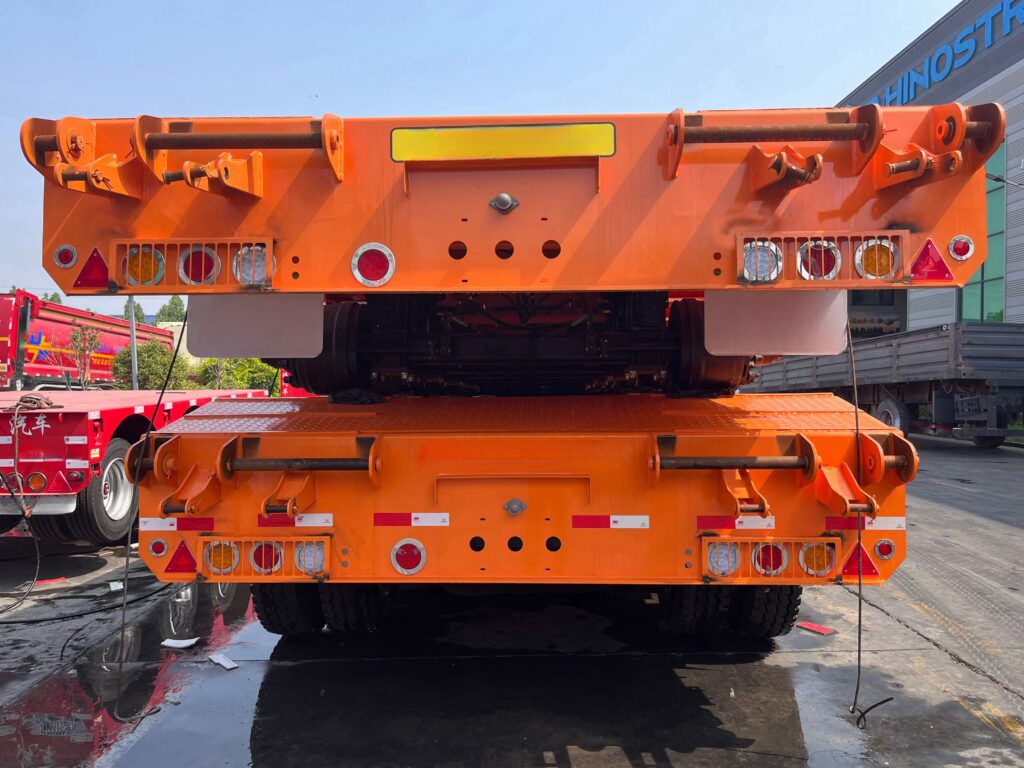 Rear view of 4 axle lowbed semi trailer showing safety taillights and heavy duty hitch locks