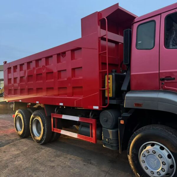 Detailed side view of red HOWO NX 371HP dump truck showing the robust tipper cargo box, heavy-duty wheels, and side protection rails