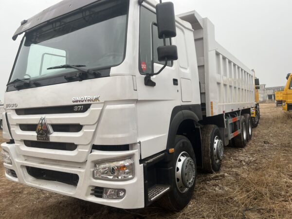 Close up of white SINOTRUK HOWO 8x4 dump truck cabin and chassis