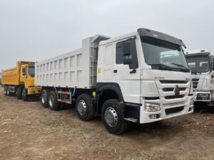 Close up of white SINOTRUK HOWO 8x4 dump truck cabin and chassis