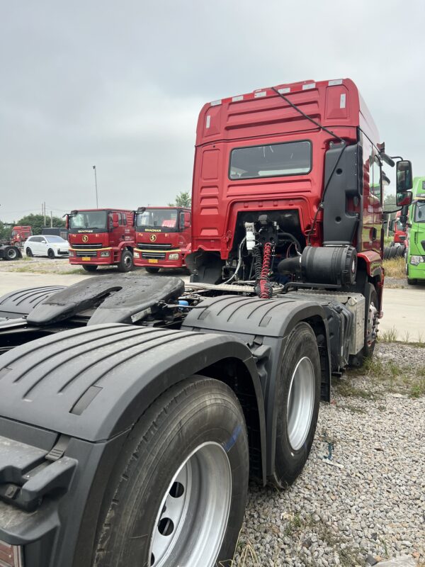 Rear back view of used red SHACMAN Delong M3000S 6x4 460HP tractor truck showing heavy duty fifth wheel coupling and dual drive tires