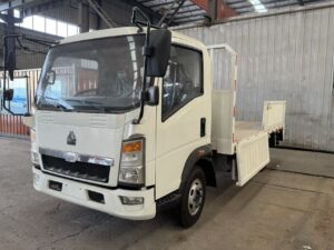 Front side view of white SINOTRUK HOWO 4x2 light cargo truck cabin with drop-side cargo box - HICA Vehicle