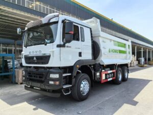 Front view of green SINOTRUK HOWO TX 6x4 dump truck cab showing front grille and headlights