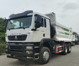Rear side view of green SINOTRUK HOWO TX 6x4 dump truck showing heavy duty cargo box and tires