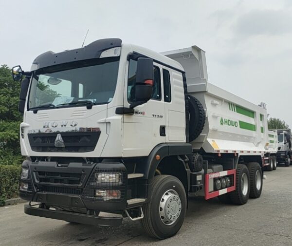 Rear side view of green SINOTRUK HOWO TX 6x4 dump truck showing heavy duty cargo box and tires