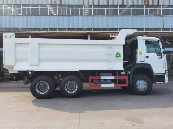 45 degree front side view of green SINOTRUK HOWO TX 6x4 dump truck on site