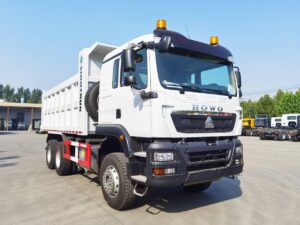Side profile view of green SINOTRUK HOWO TX 6x4 dump truck on site