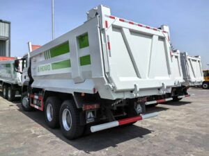 Rear view of green SINOTRUK HOWO TX dump truck showing cargo box and tail gate structure