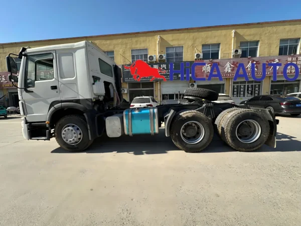 Left side full view of white SINOTRUK HOWO 430HP 6x4 tractor truck showing aluminum fuel tank and chassis