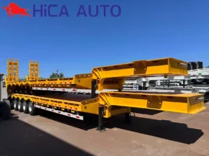 Yellow 4-axle hydraulic gooseneck lowbed semi-trailer with folding ramps for heavy equipment haulage