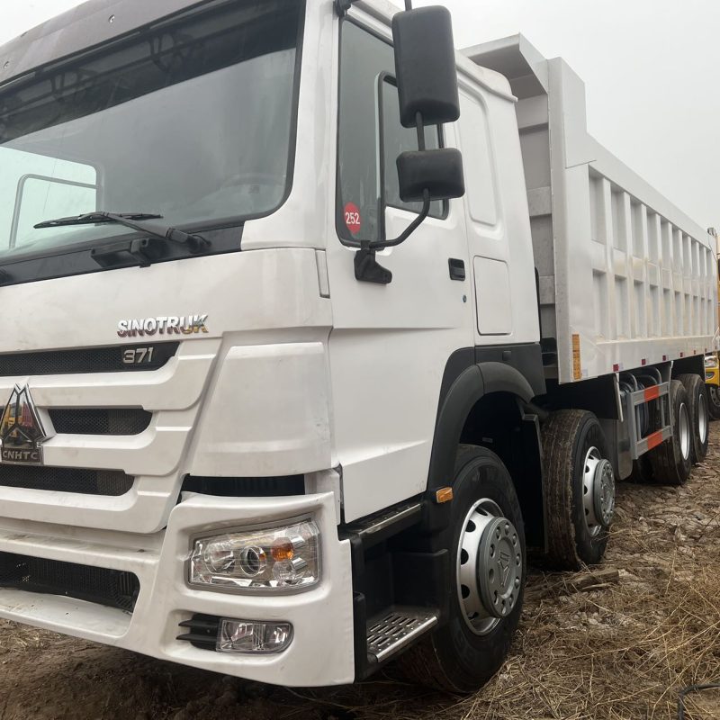 Close up of white SINOTRUK HOWO 8x4 dump truck cabin and chassis